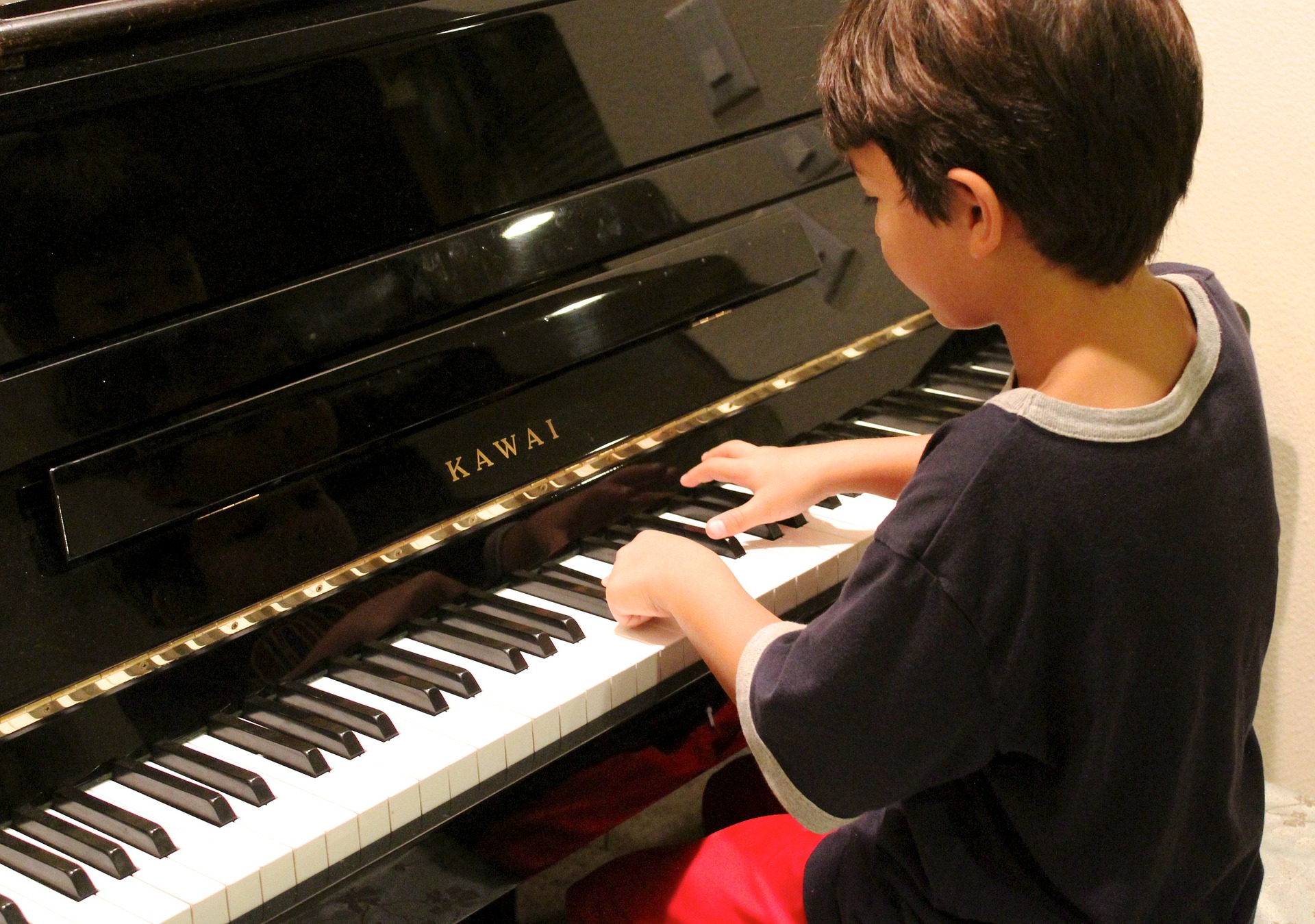 Junge spielt Klavier - so kann Musik in der Schule aussehen