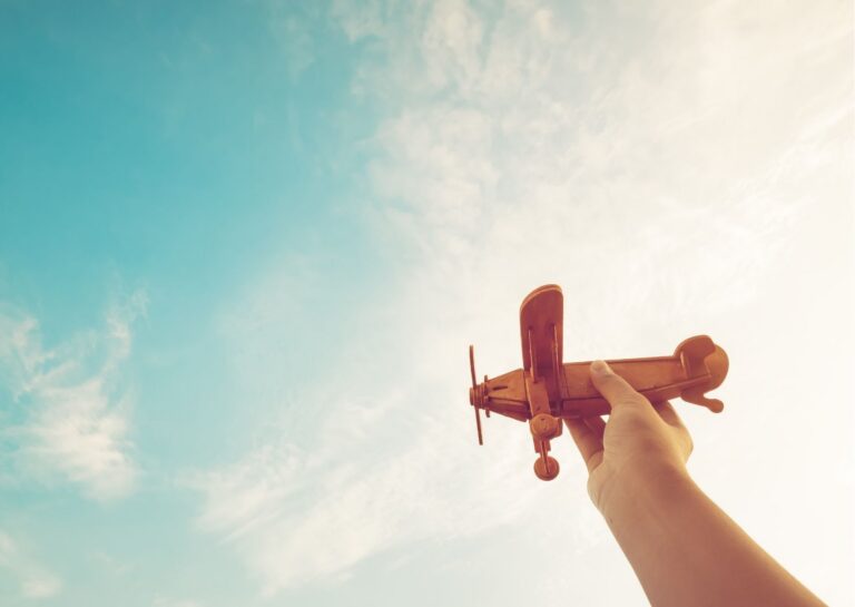 Kinderhand mit einem Flugzeugspielzeug - Beitragsbild zum Thema: Selbstzweifel überwinden