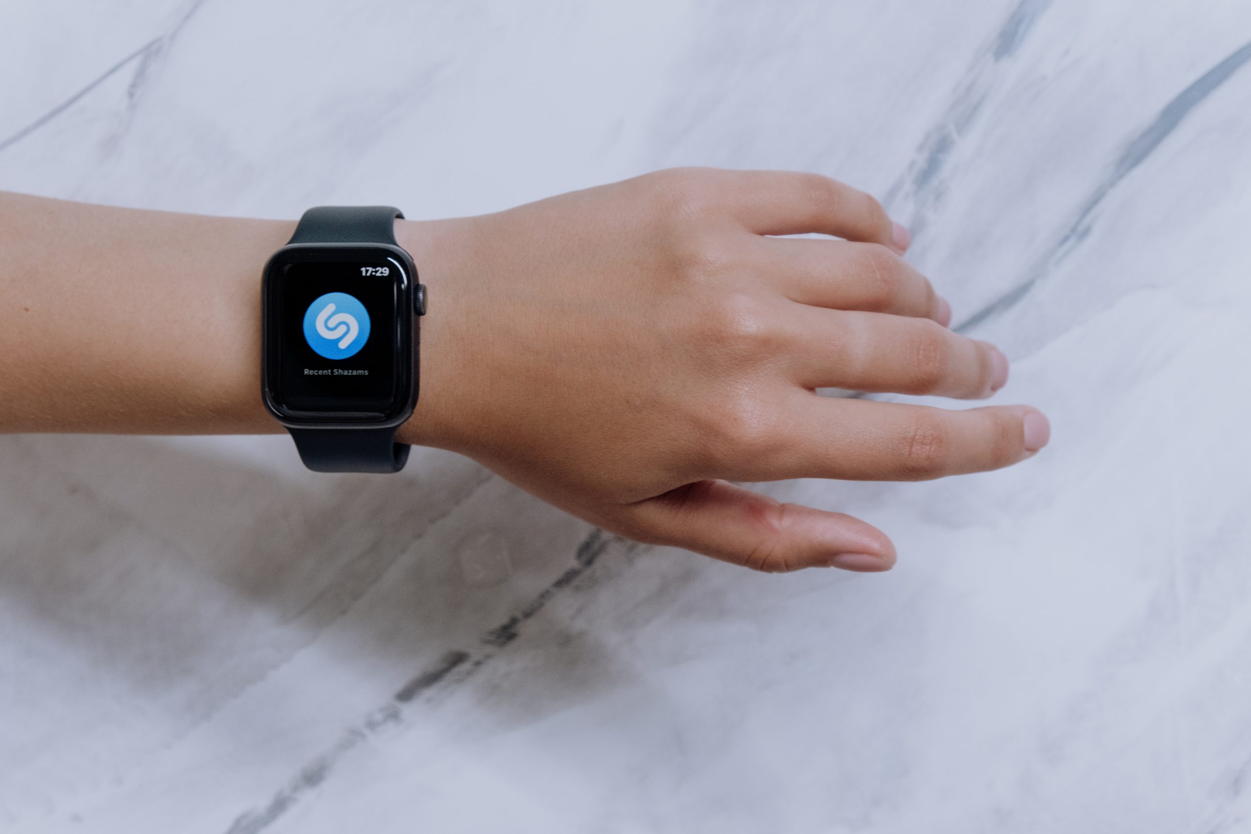 Musik erkennen – mit Song Erkennungs-Apps und Programmen Auf einer Smart-Uhr wird die Song Erkennungs-App Shazam angezeigt. Musik erkennen einfach gemacht.