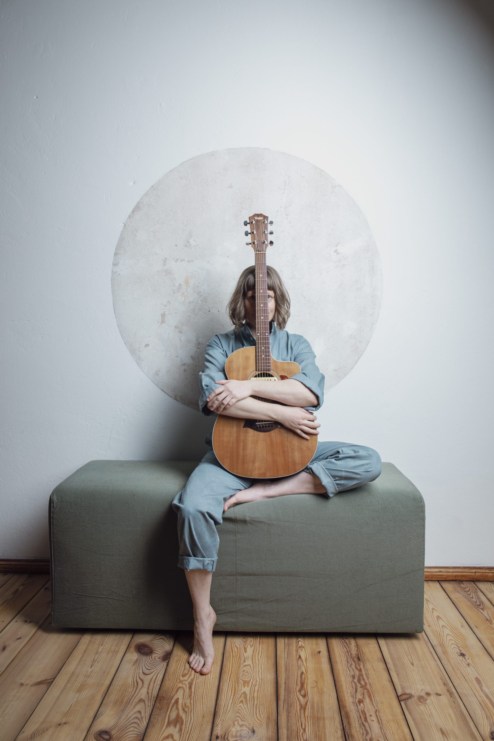 Teresa Bergman – mit großer Stimme auf zu neuen Ufern Ein Portrait der Musikerin Teresa Bergman. Sie sitzt auf einem Hocker und hält eine Gitarre vor sich