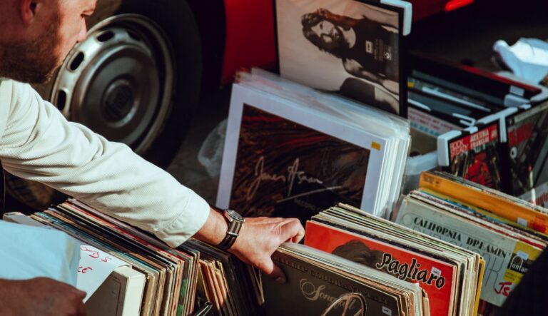 Ein Mann zieht eine Vinylplatte aus einem Verkaufsstand