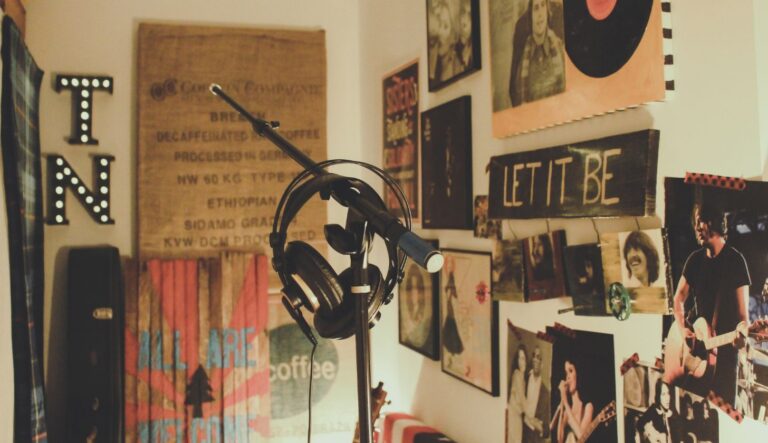 Ein leerer Mikrofonständer, darüber hängen Kopfhörer, im Raum hängen Musikplakate