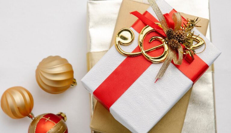 Ein Weihnachtsgeschenk für Musiker mit roter Schleife und einem goldenen Notenschlüssel