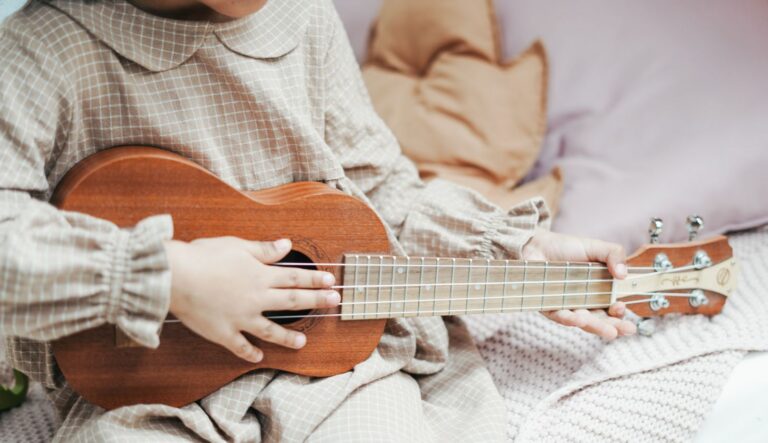 Eine Nahaufnahme eines Menschen der oder die ein altes Saiteninstrument spielt