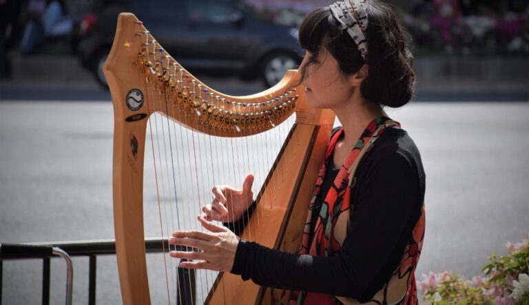 Eine Frau sitzt am Wasser und spielt Harfe