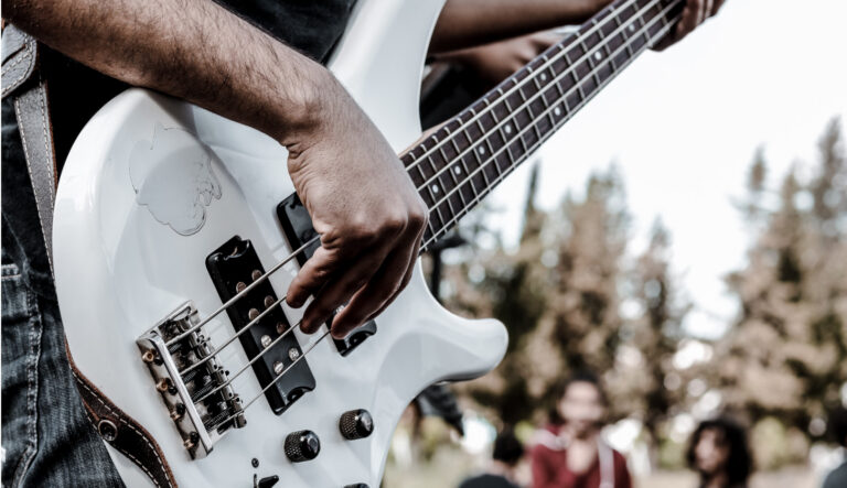 Mann im schwarzen T-Shirt spielt weiße Bassgitarre – Kostenloses Graues Bild auf Unsplash
