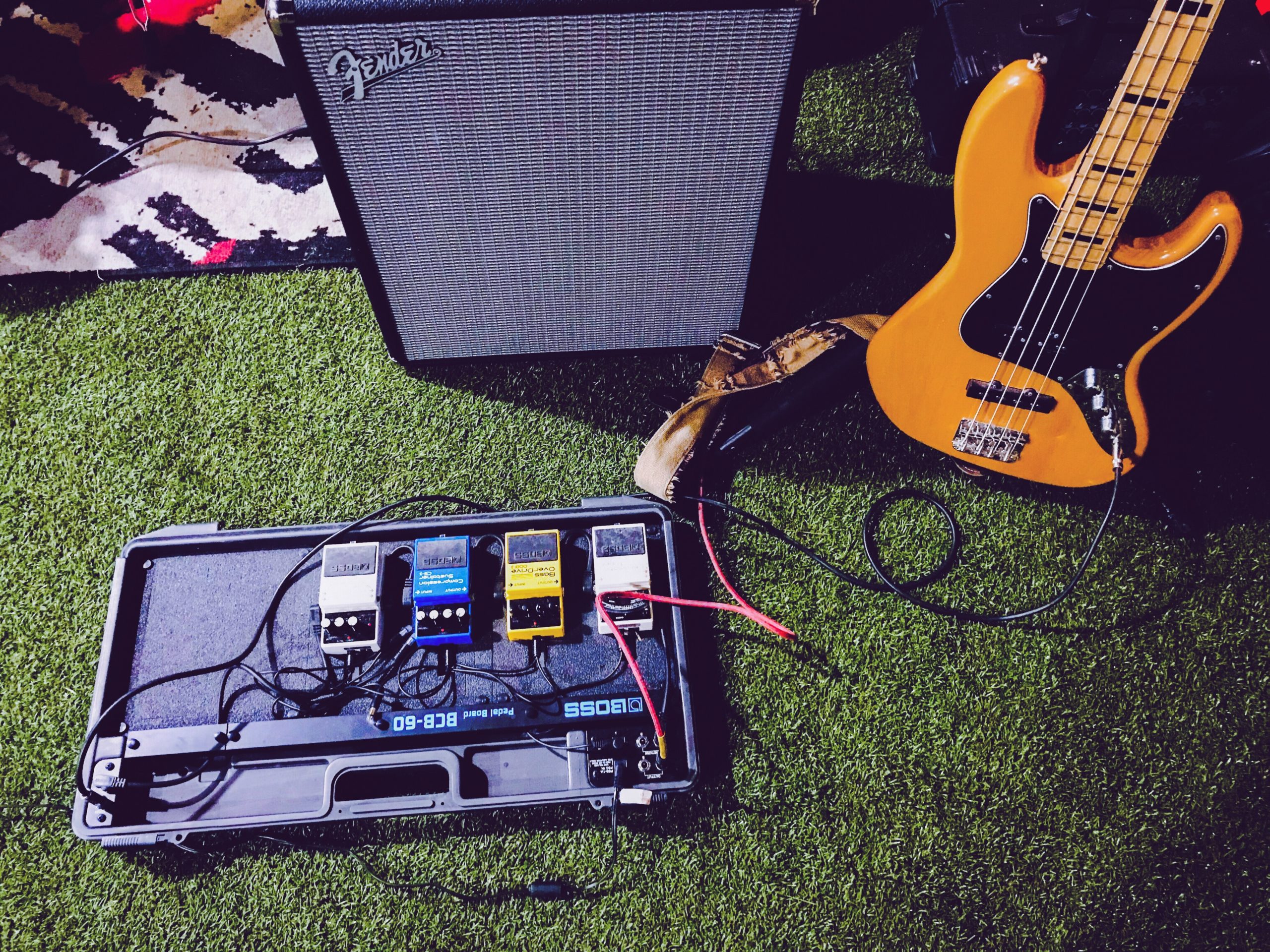 Gelbe E-Bassgitarre neben schwarzem Fender-Gitarrenverstärker
